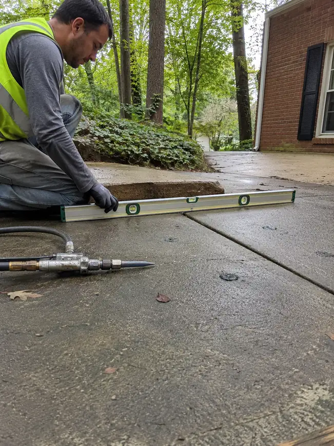 Checking a leveled concrete slab for a flush finish in Ellicott City, MD